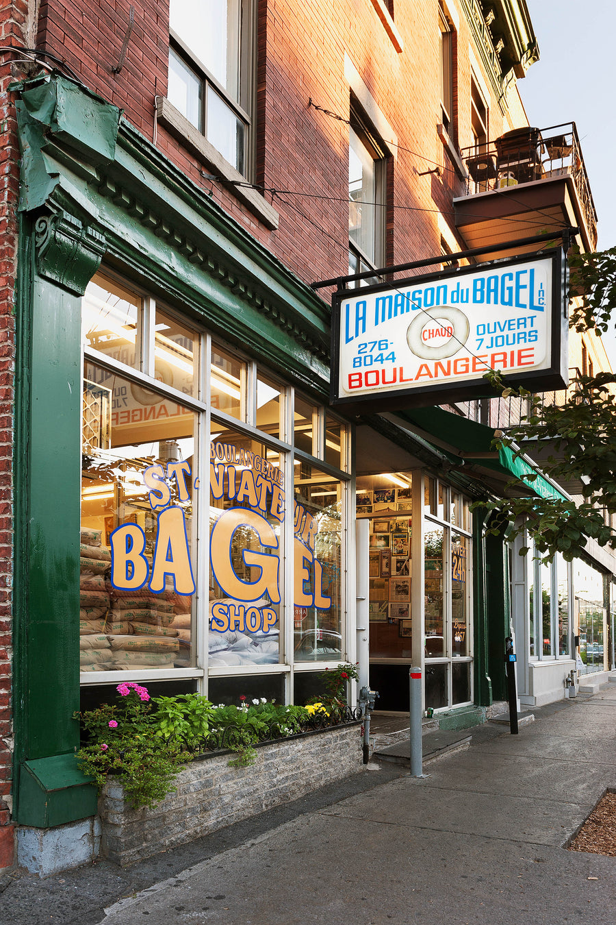 The green-trimmed St-Viateur Bagel storefront on rue Saint-Viateur, its neon 'La Maison du Bagel' sign lit